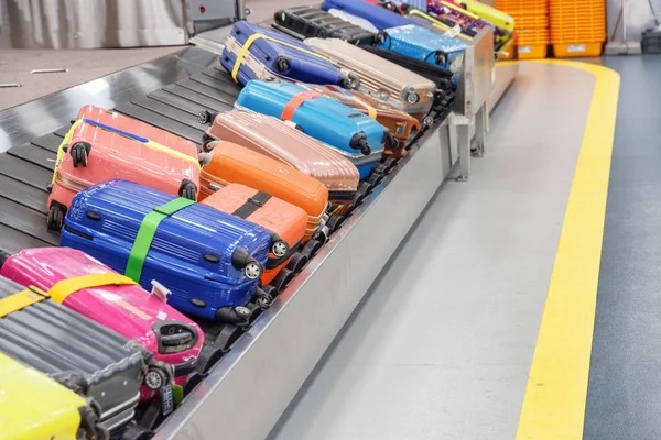 机场客运码头到达区行李传送带上有明亮多彩多姿的箱包 行李传送带 — 图库照片