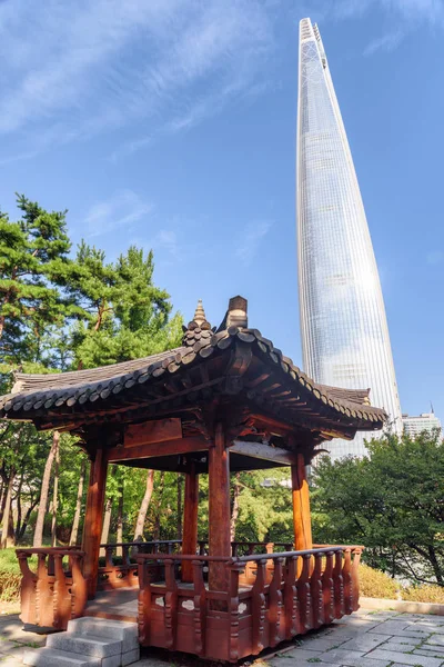 韩国首尔市中心公园绿树成荫的传统韩国建筑的木制亭子 白色摩天大楼在蓝天背景下可见 风光明媚的城市景观 — 图库照片
