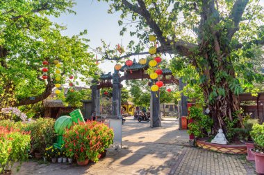 Hoi bir (Hoian), Vietnam - 11 Nisan 2018: Hoi An antik kenti Phap Bao tapınak alanında geleneksel sarı ve kırmızı ipek fenerler güzel yeşil ağaçlar süslenmiş.