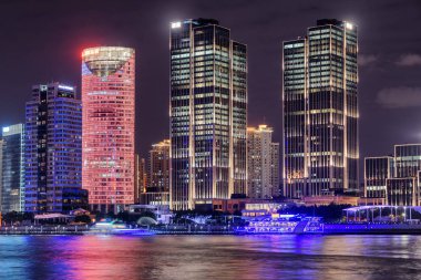 Shanghai, Çin'in şehir merkezindeki Pudong Yeni alan (Lujiazui) modern waterfront binalara inanılmaz gece manzarası. Huangpu Nehri suya yansıyan renkli şehir ışıkları.