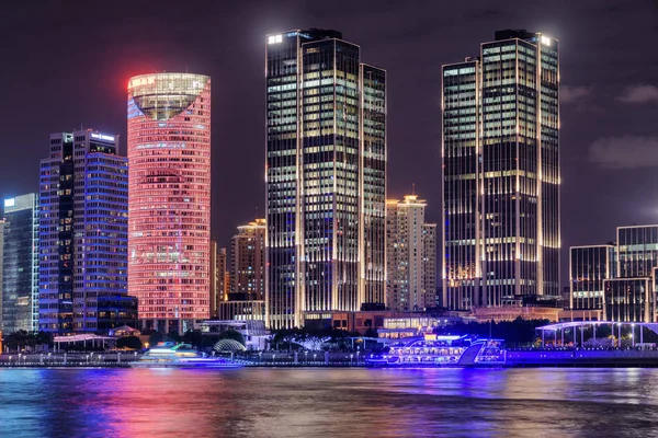 Amazing night view of modern waterfront buildings at the Pudong New Area (Lujiazui) in downtown of Shanghai, China. Colorful city lights reflected in water of the Huangpu River.