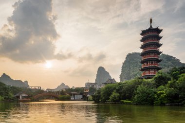 Güzel bir akşam görünümü Guilin, Çin için yeşil ormanlar ve doğal Karstik dağlar arasında Mulong Gölü (tahta Dragon göl). Harika pagoda günbatımında sağ tarafta görünür. Muhteşem manzara.