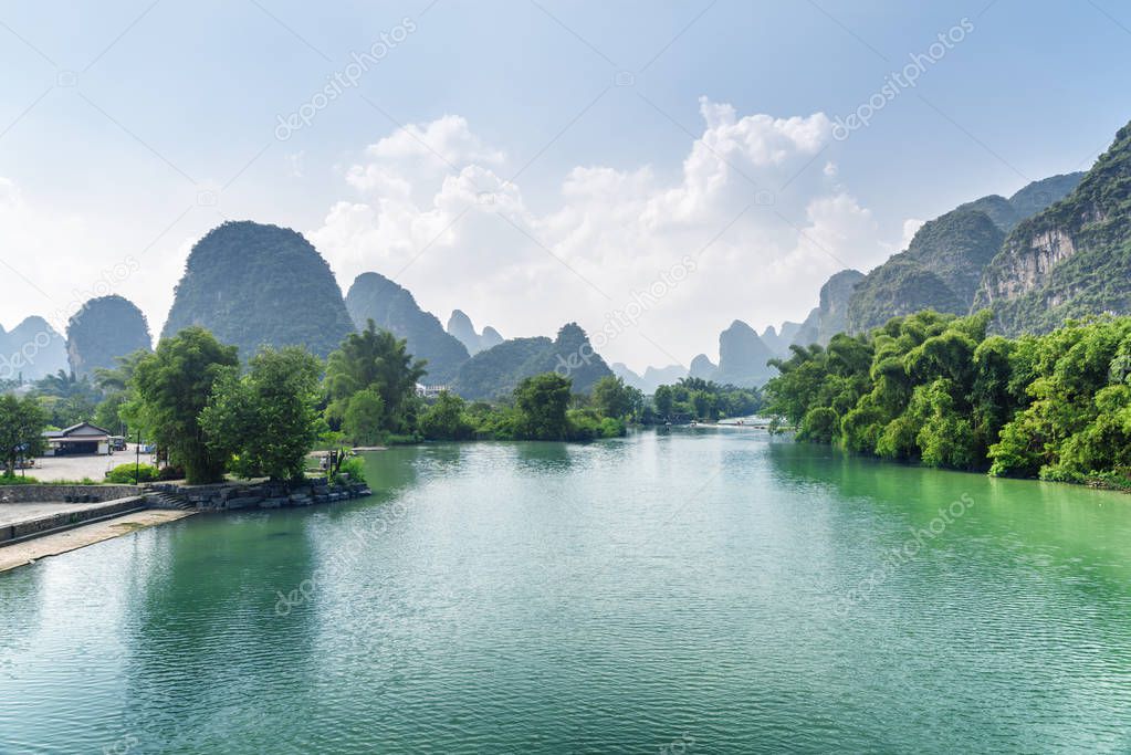 Amazing view of the Yulong River with azure water at Yangshuo County of Guilin, China. Beautiful karst mountains are visible on blue sky background on summer day. Wonderful landscape.