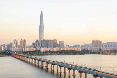 Şaşırtıcı günbatımı Güney Kore'de Seul şehir, modern kuleye bakış. Güzel gökdelen ve Jamsil demiryolu Köprüsü Han Nehri (Hangang). Harika cityscape.