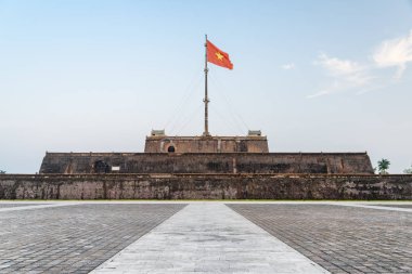 Akşam görünümü Vietnam (kırmızı bayrak altın bir yıldız ile) bir kule mavi gökyüzü arka plan Hue, Vietnam için üzerinde kalenin içinde çırpınan bayrak ve bir kare. Kalenin içinde imparatorluk kentidir.