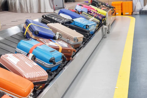 Heldere koffers en tassen op de transportband bagage in luchthaven — Stockfoto