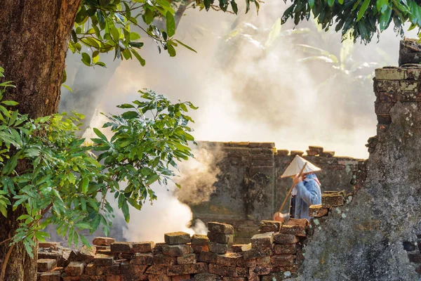 Mulher vietnamita trabalhando entre ruínas de edifícios antigos, Hue — Fotografia de Stock