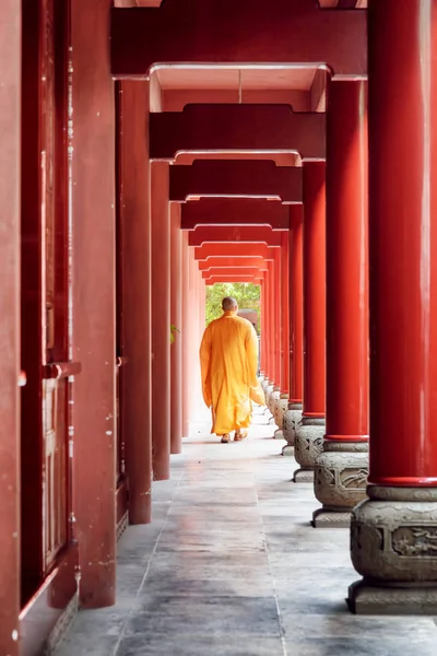 Çinli bir tapınağın kırmızı koridordan yürürken Budist rahip — Stok fotoğraf