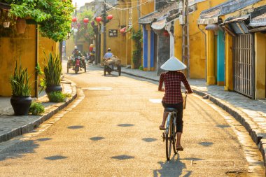 Hoi An boyunca geleneksel şapka bisikletleme Vietnamlı kadın