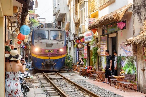 Tåg passerar genom en smal gata i Hanoi, Vietnam — Stockfoto