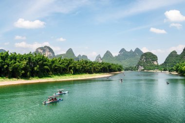 Masmavi su ile Li Nehri üzerinde turist motorlu sallar