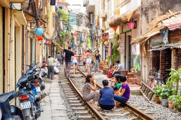 Mujeres vietnamitas descansando en el ferrocarril en la calle Hanoi — Foto de Stock