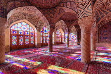Nasir al-Mulk Camii 'nde (Pembe Cami) inanılmaz boş ibadet salonu. Güneş ışığının muhteşem manzarası yerdeki renkli vitray pencerelerden yansıyor..