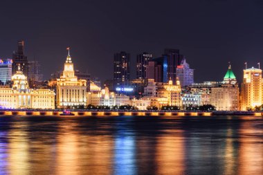 Şangay, Çin - 4 Ekim 2017: Bund (Waitan) 'ın muhteşem gece manzarası. Renkli şehir ışıkları suya yansıyor. Huangpu Nehri 'nin rıhtımı Asya' nın popüler bir turizm merkezidir..