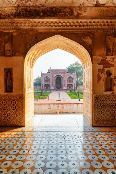 Awesome view of red sandstone building through arched gate at the Tomb of Itimad-ud-Daulah (Baby Taj). Agra is a popular tourist destination of South Asia.