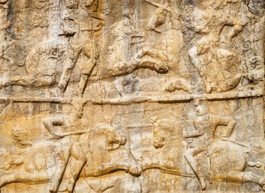İran 'daki Necropolis Naqsh-e Rustam' da kadim bas-rahatlaması. Achaemenid krallarına ait büyük bir mezarın ayrıntıları yerden oldukça yüksek bir yükseklikte kaya yüzeyinden oyulmuş..