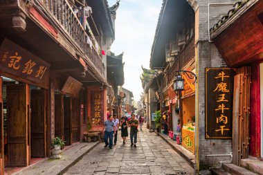 Fenghuang, Çin - 23 Eylül 2017: Phoenix Antik Kenti 'nin (Fenghuang İlçesi) sıcacık dar sokağının muhteşem manzarası. İnanılmaz otantik evler. Fenghuang, Asya 'nın popüler bir turizm merkezidir..