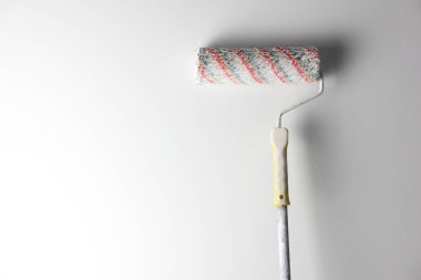 Beyaz duvar arka plan üzerinde boya silindiri