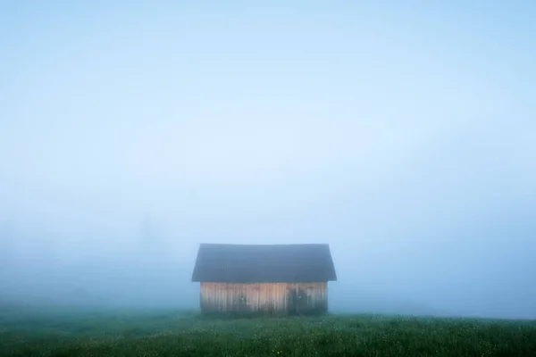 Sozinha casa no prado nebuloso — Fotografia de Stock