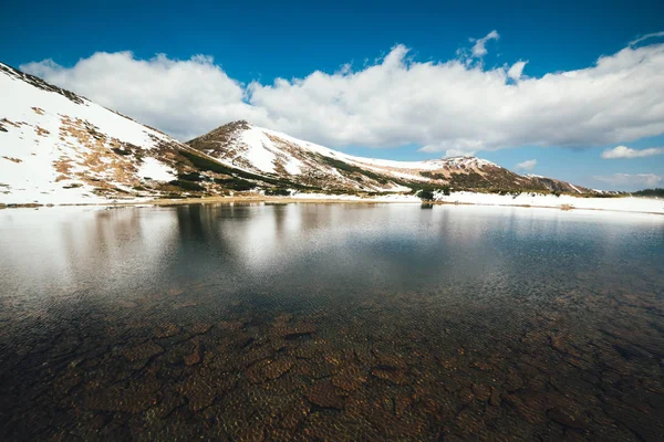 Frozen mountain lake with blue ice — Stock Photo, Image