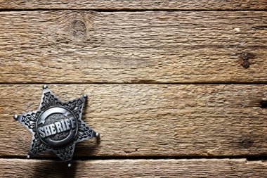 Sheriff star on wooden table clipart