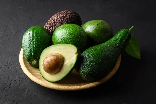 Свіжі фрукти авокадо на дерев'яній тарілці — стокове фото