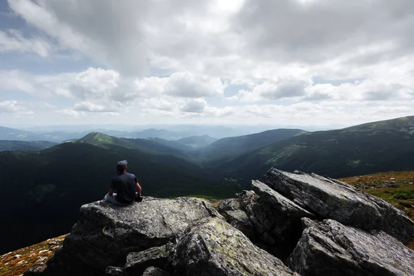 Самотній турист сидить на краю скелі — стокове фото