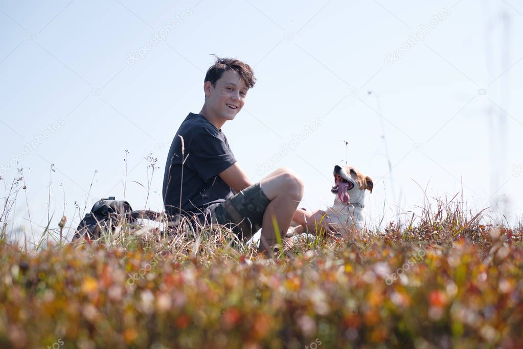 Teenager on autumn lawn with small white dog