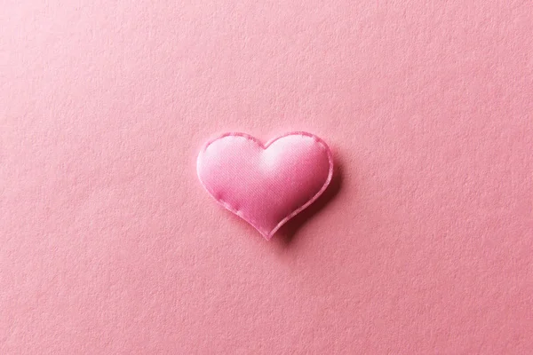 Розовое текстильное сердце на розовом фоне — стоковое фото