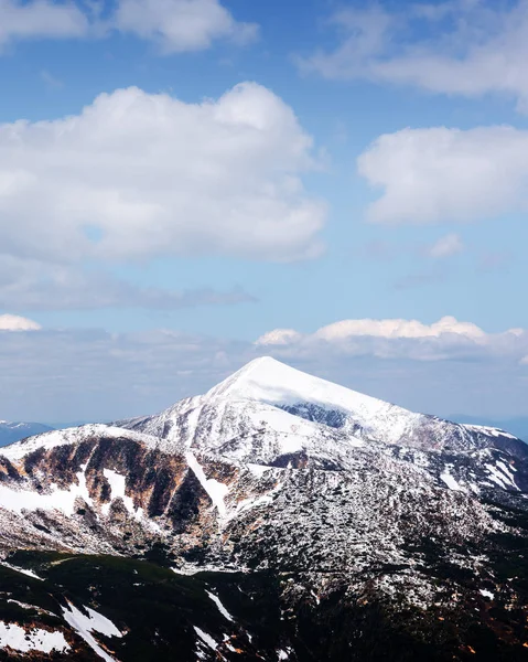 Vista sulle colline rocciose con neve e cielo azzurro — Foto Stock