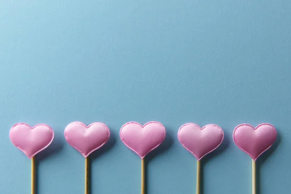 Розовые текстильные сердца на деревянных палочках крупным планом — стоковое фото