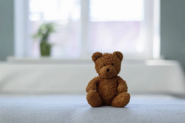 Plush teddy bear toy on white bed — Stock Photo, Image
