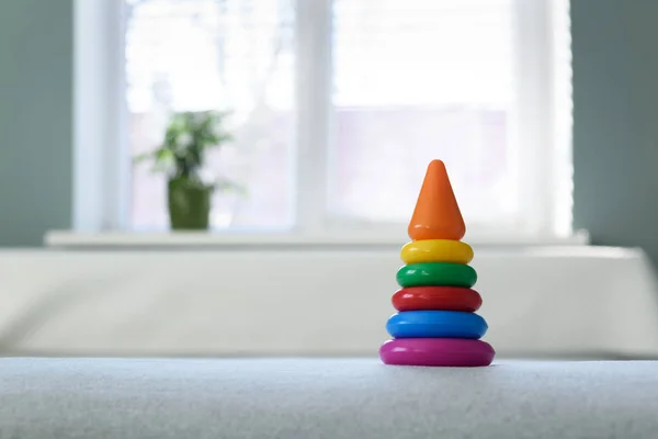 Gekleurde piramide speelgoed op witte bed — Stockfoto