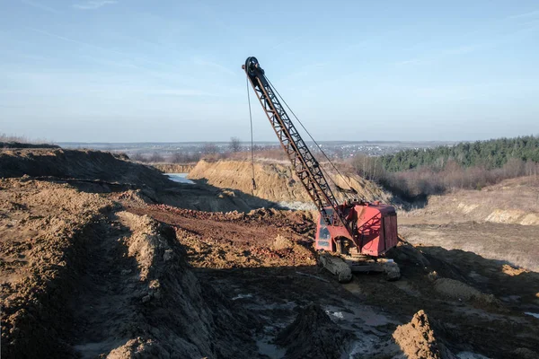 Excavator in the red clay quarry — Stock Photo, Image