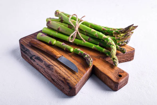 Broto de espargos verdes em tábua de madeira — Fotografia de Stock