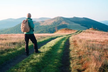 Sırt çantalı bir adam dağ yolunda