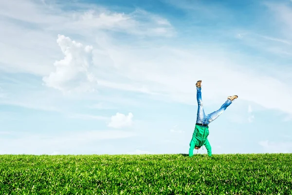 Man doing wheel exercise on amazing meadow — Stock Photo, Image