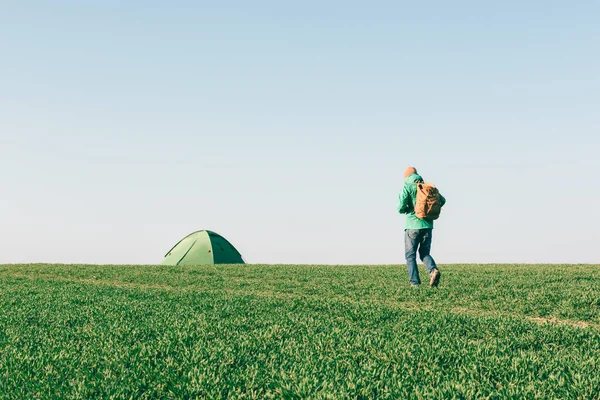Турист с рюкзаком идет к своей палатке — стоковое фото