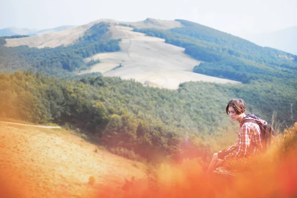 Мальчик с рюкзаком в красивых осенних горах — стоковое фото
