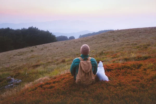 Samotny turysta siedzi w czerwonej trawie — Zdjęcie stockowe