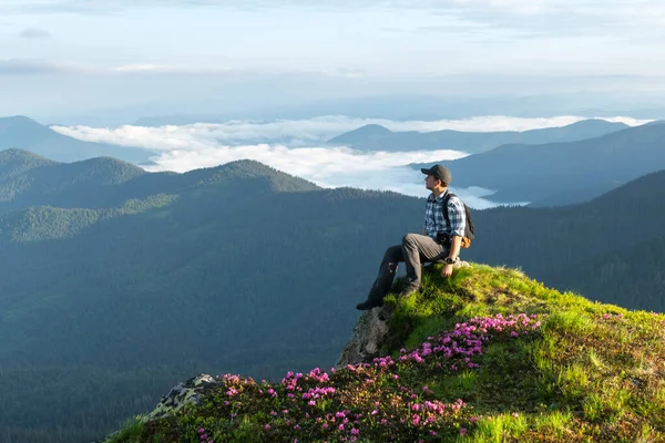 Ein Tourist sitzt am Rande einer Klippe — Stockfoto