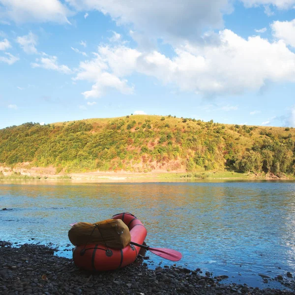 Barco de goma naranja packraft con mochila en un río — Foto de Stock