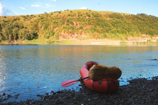 川にバックパック付きオレンジパッククラフトゴムボート — ストック写真