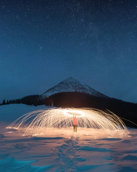 Espectáculo de fuego con muchas chispas en las montañas nocturnas de invierno —  Fotos de Stock