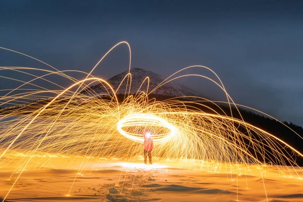 Spectacle de feu avec beaucoup d'étincelles dans les montagnes d'hiver de nuit — Photo