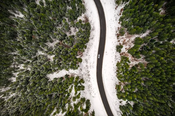Vol au-dessus des montagnes d'hiver avec serpentine de route — Photo
