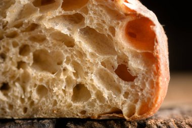 Köy tahtasında gözenekli ekmek kırıntısı ve çıtır çıtır deri. Makro ekşi somun dokusu.