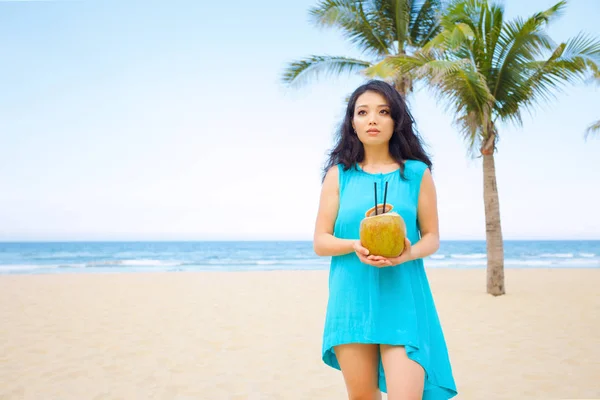年轻美丽的亚洲妇女正在热带海边喝椰汁 — 图库照片