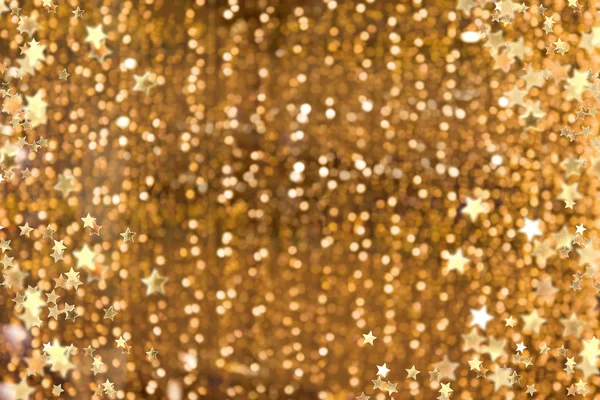 輝く金色の背景 クリスマスと年末年始に点灯します キラキラ デフォーカス背景と点滅の星や火花 — ストック写真