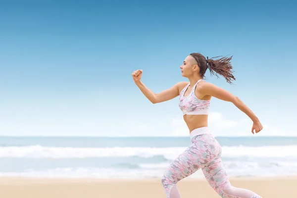 Jovem atleta mulher correndo na praia do mar — Fotografia de Stock